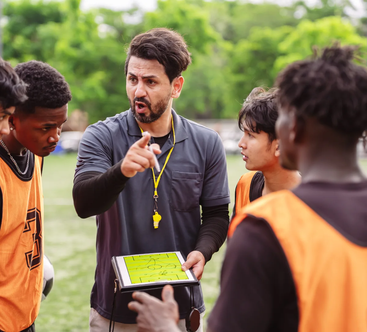 Entrenador explicando una táctica a un grupo de futbolistas